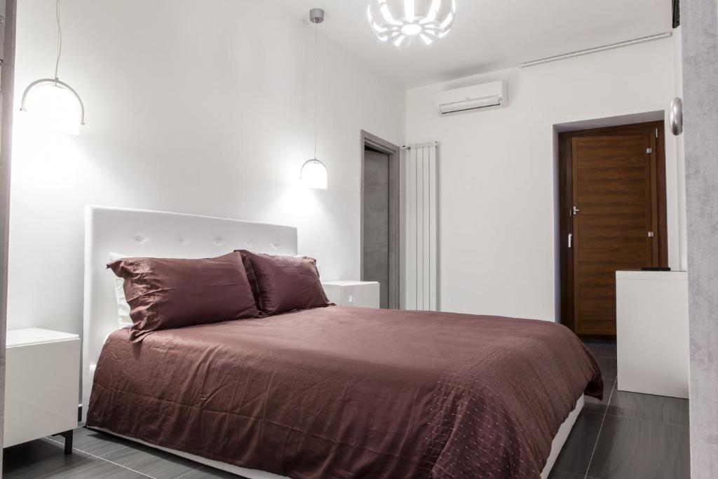 a bedroom with a large bed with a brown blanket at Pomodoro Bed in Castrovillari