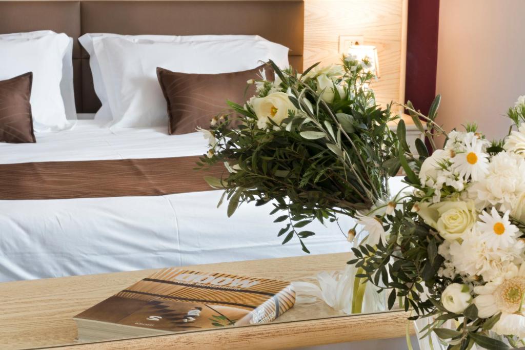 1 dormitorio con 1 cama y 1 mesa con flores en Hotel Soleluna, en Piano di Sorrento