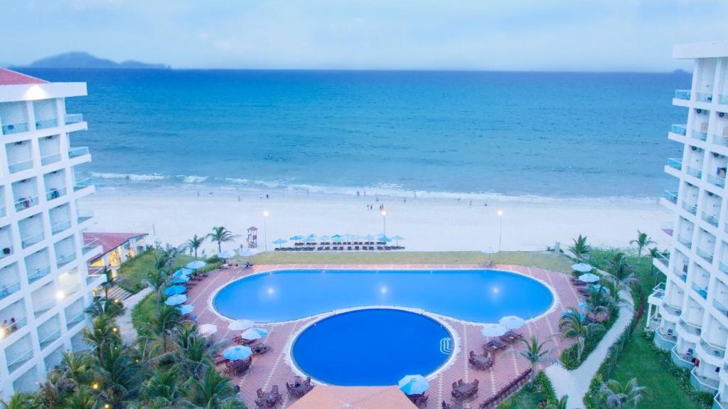a view of the beach from the balcony of a resort at Golden Peak Resort & Spa in Cam Ranh