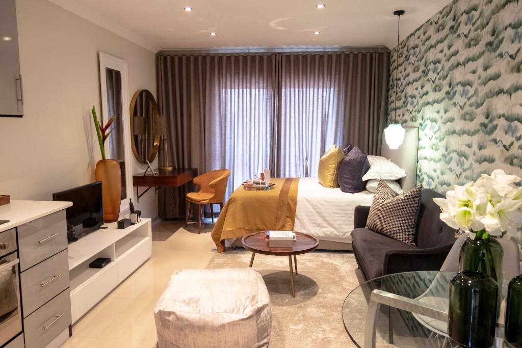 Habitación de hotel con cama y sala de estar. en The Wilcrest Apartment, en Randjesfontein