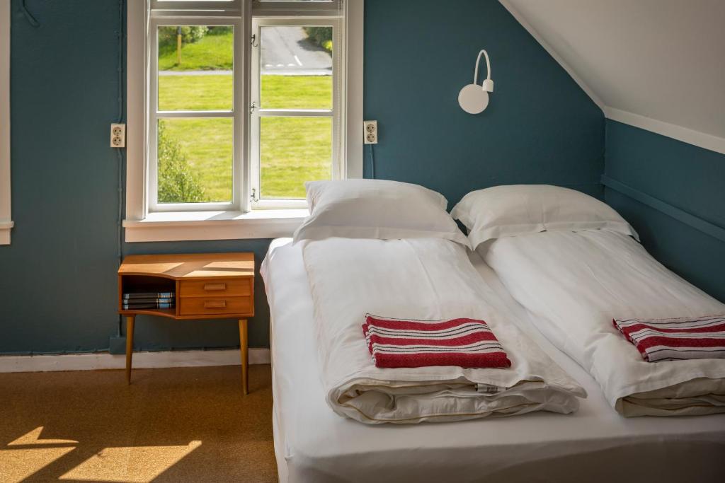 a bedroom with two beds and a window at Hafaldan HI hostel, old hospital building in Seyðisfjörður