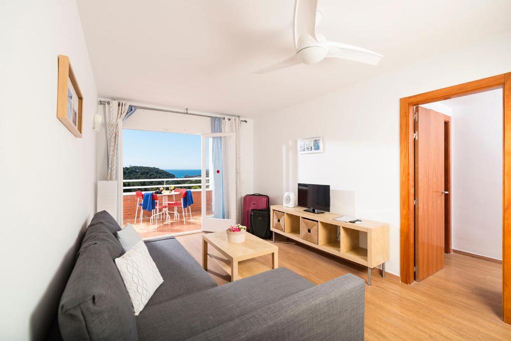 a living room with a couch and a television at Apartaments Els Llorers in Lloret de Mar