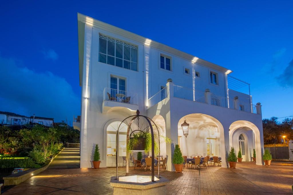 a white building with a courtyard in front of it at Relais Palazzo del Barone in Sorrento