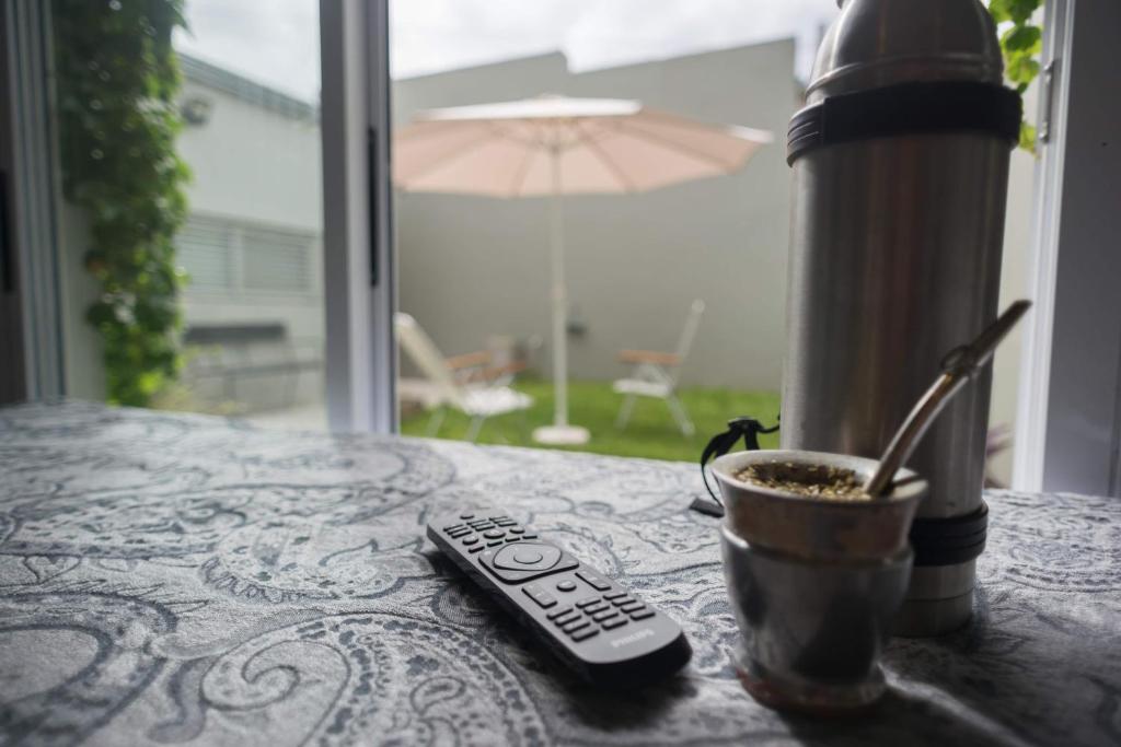 una mesa con mando a distancia y una taza de café en Loft La Plata en La Plata