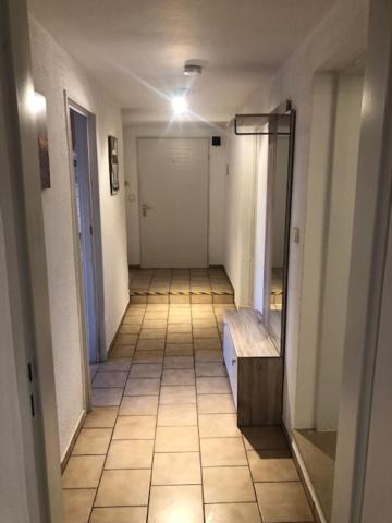 a hallway with a tile floor and a hallway with a mirror at Monteurzimmer Rodenbach in Rodenbach
