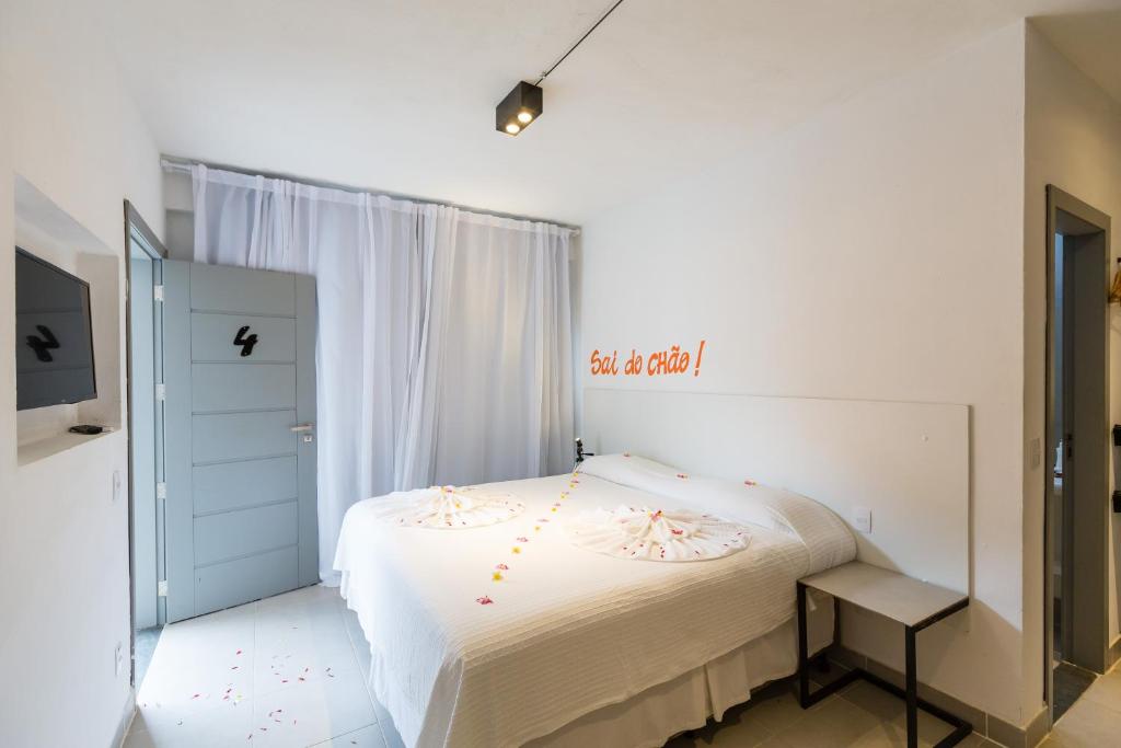um quarto com uma cama branca e uma janela em Villa Amado em Morro de São Paulo