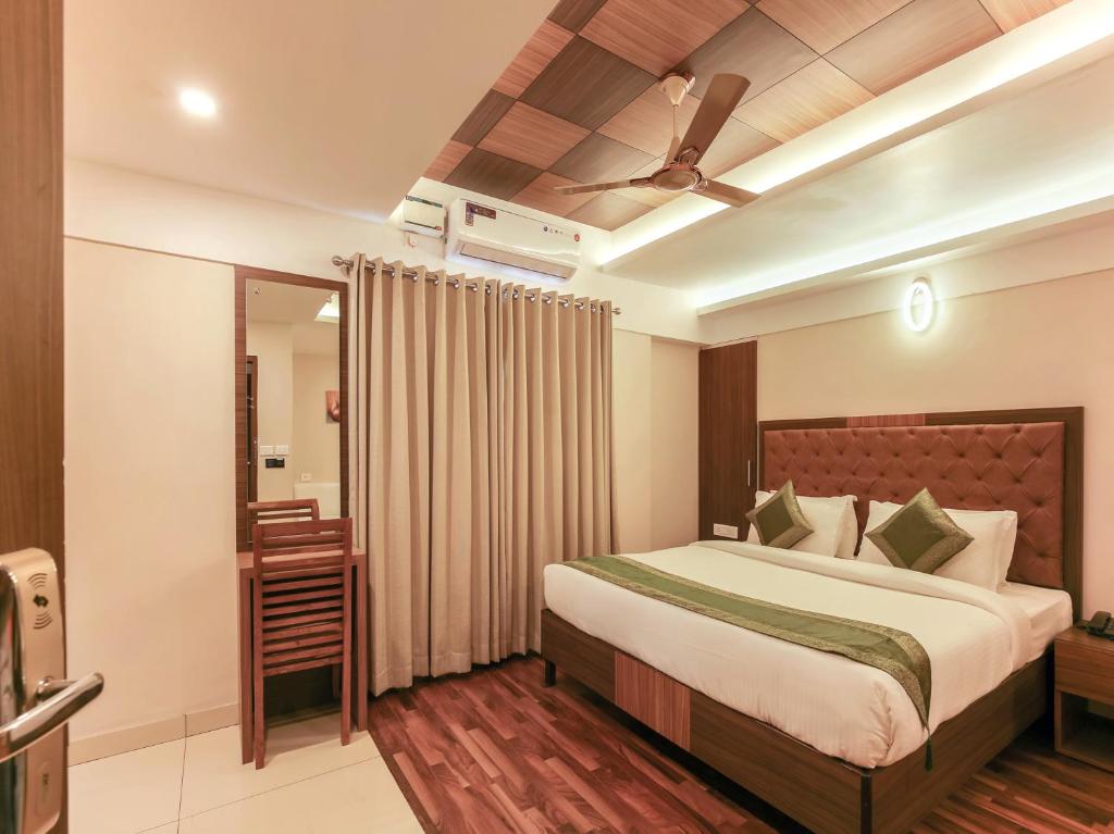 a bedroom with a bed and a ceiling fan at Treebo Trend Goodland Residency in Trivandrum