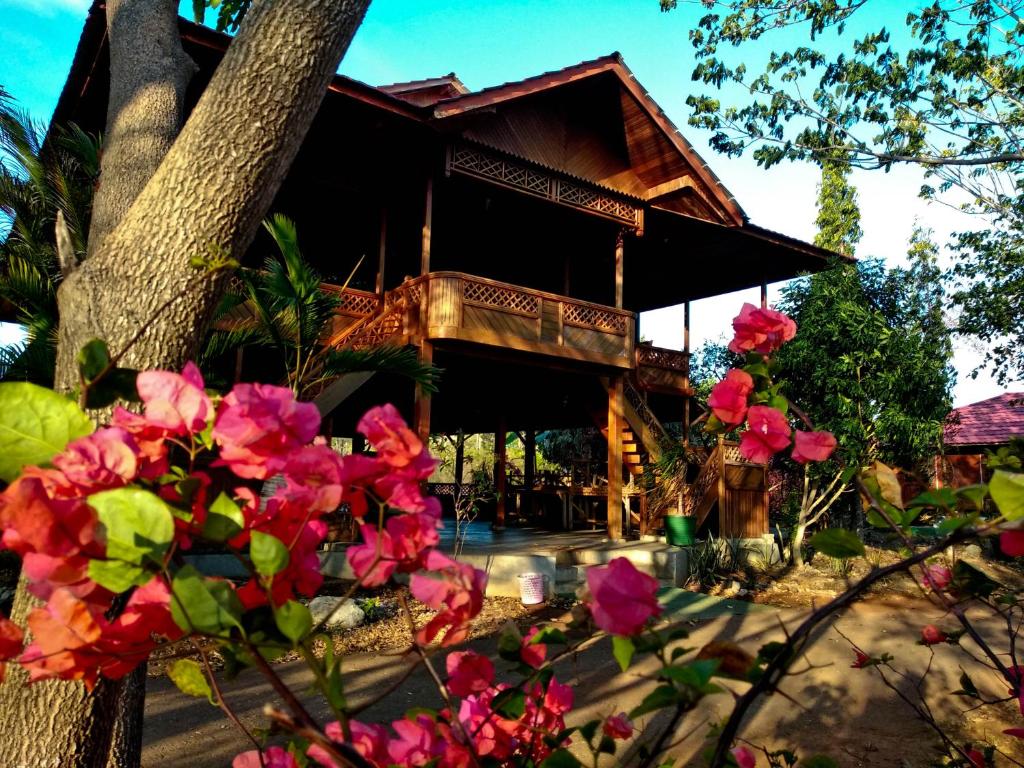 a house with pink flowers in front of it at Nirwana Buton Villa in Baubau
