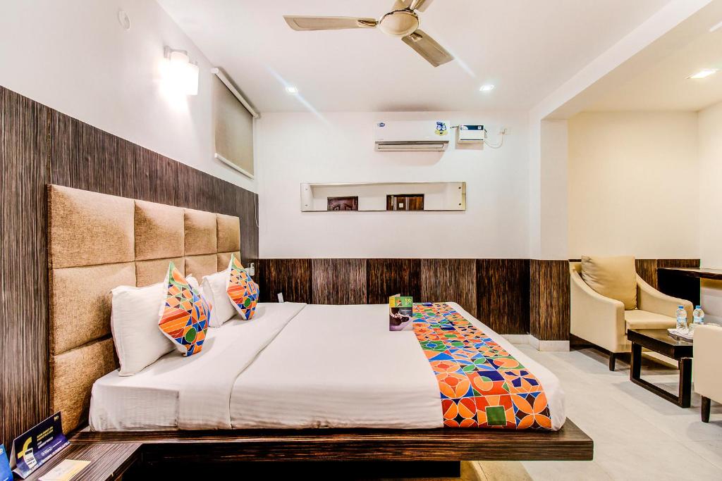 a bedroom with a large bed and a desk at Capital Residency in Bangalore