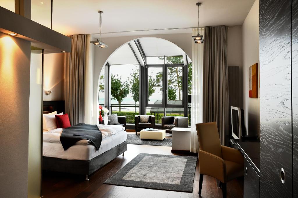 ein Schlafzimmer mit einem Bett und ein Wohnzimmer in der Unterkunft niXe Boutiquehotel & Spa in Binz
