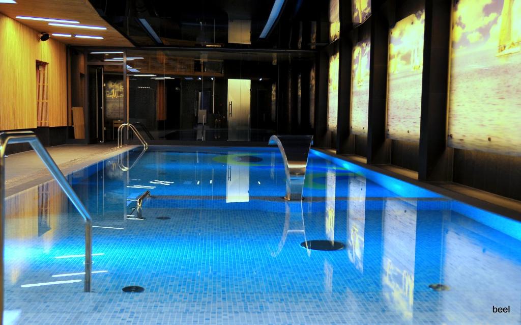 a swimming pool in a building with blue water at Regatta Hotel Restauracja Spa in Poznań