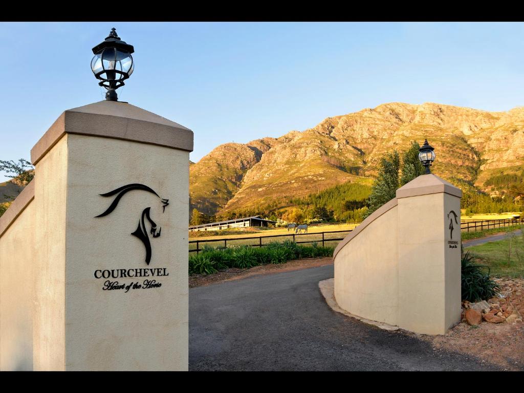 a gate with a street light on top of a wall at Courchevel Cottages in Franschhoek