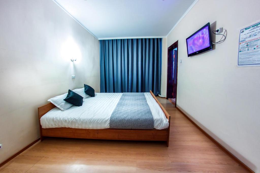 ハバロフスクにあるRio Hotelのベッドルーム1室(ベッド1台、壁にテレビ付)