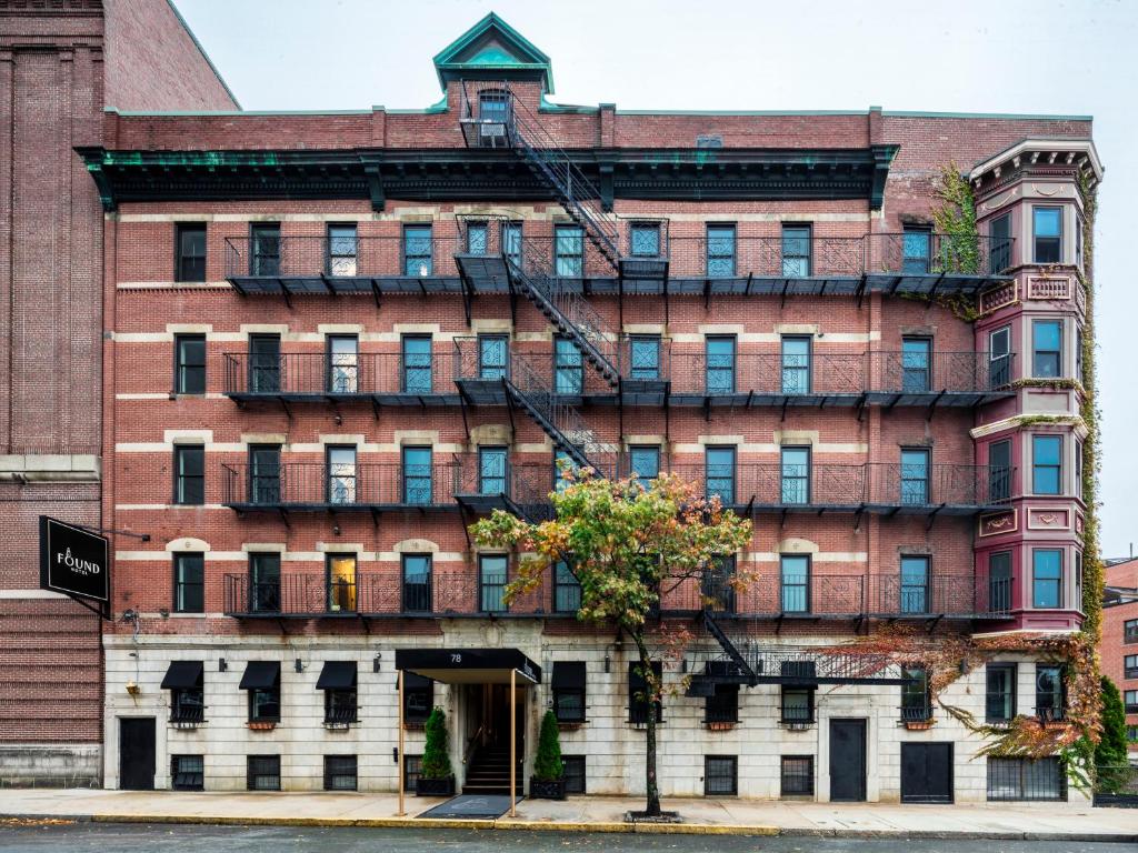 un edificio de ladrillo rojo con un árbol delante de él en Found Hotel Boston Common, en Boston