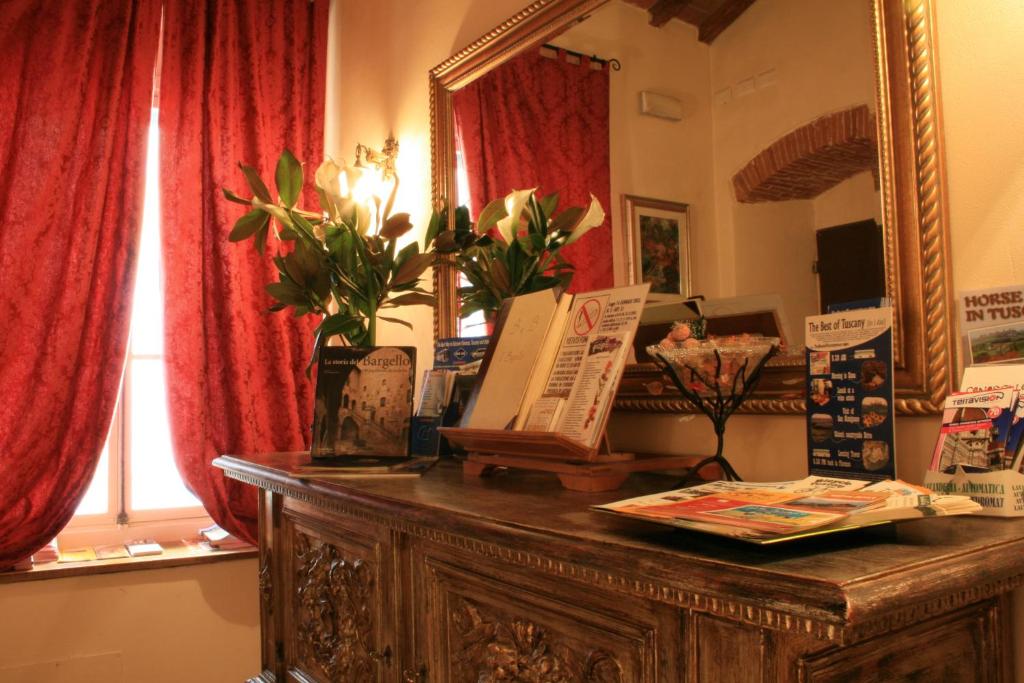 a mirror sitting on top of a wooden dresser at Bed & Breakfast Il Bargello in Florence