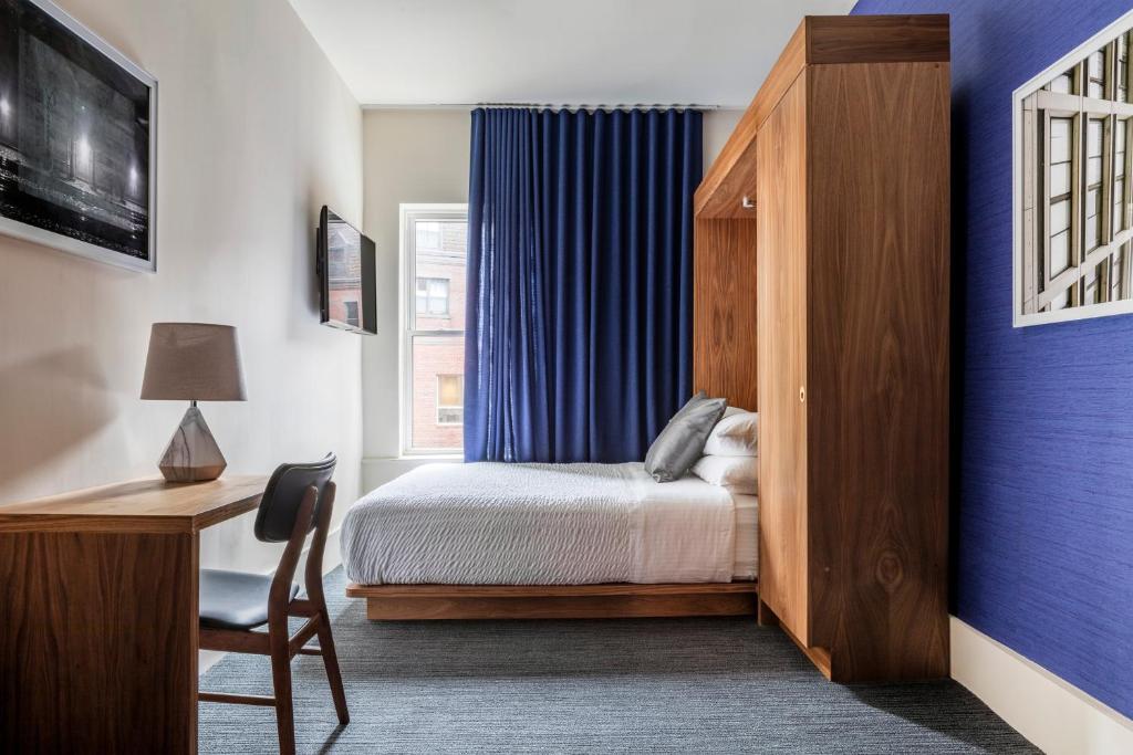 a bedroom with a bed and a desk and a window at Hotel Ivy Boston Common in Boston