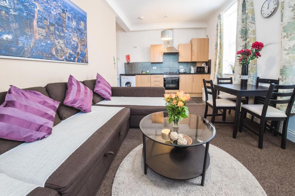 a living room with a couch and a table at Ilford Central Luxury Apartments in Ilford