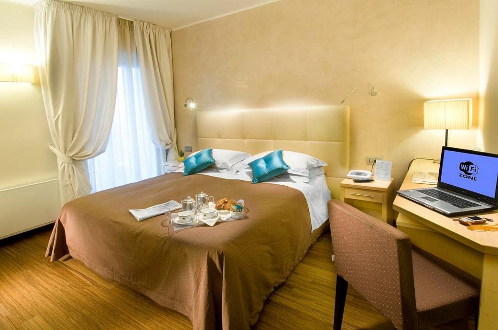 Postel nebo postele na pokoji v ubytování Hotel Sarti