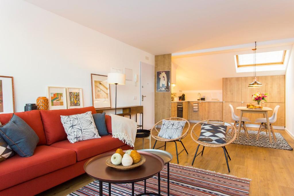 a living room with a red couch and a table at Amazing City Center 2 bdr flat! in Lisbon