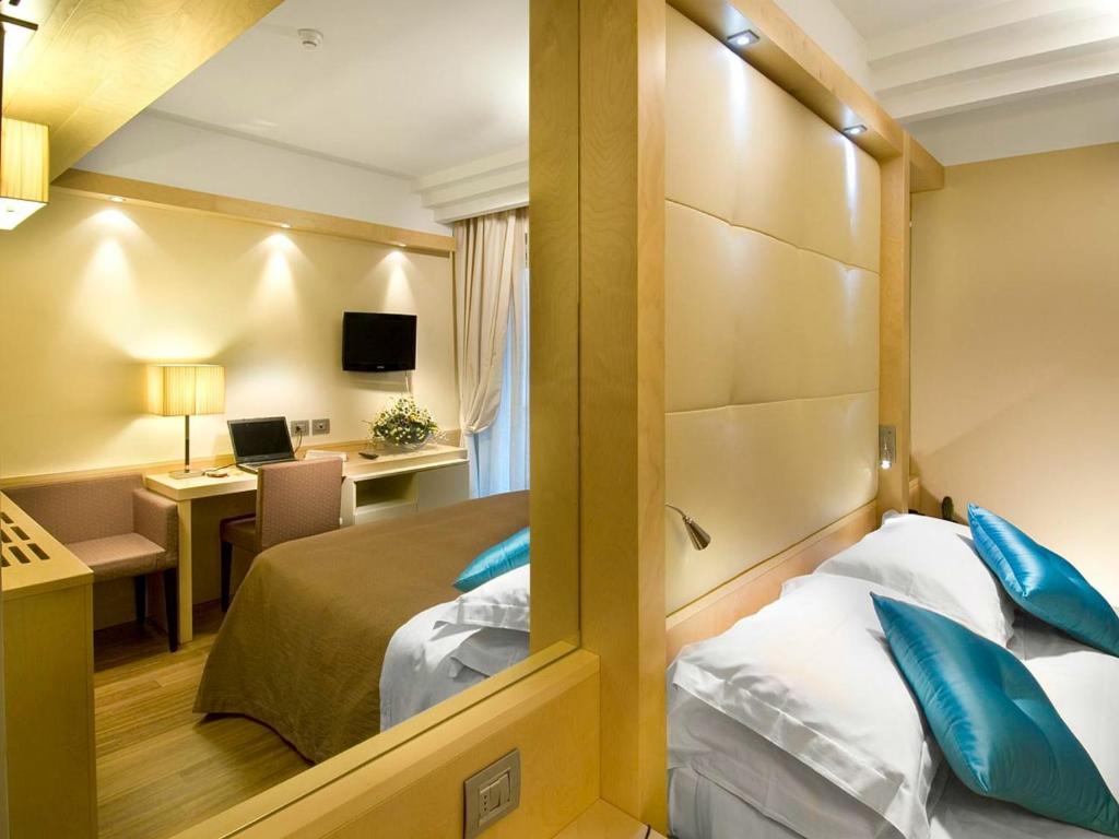 Postel nebo postele na pokoji v ubytování Hotel Sarti