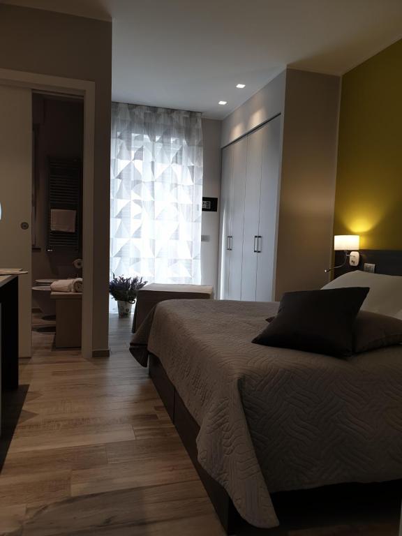 een slaapkamer met een bed en een groot raam bij Camomilla B&B in Alba