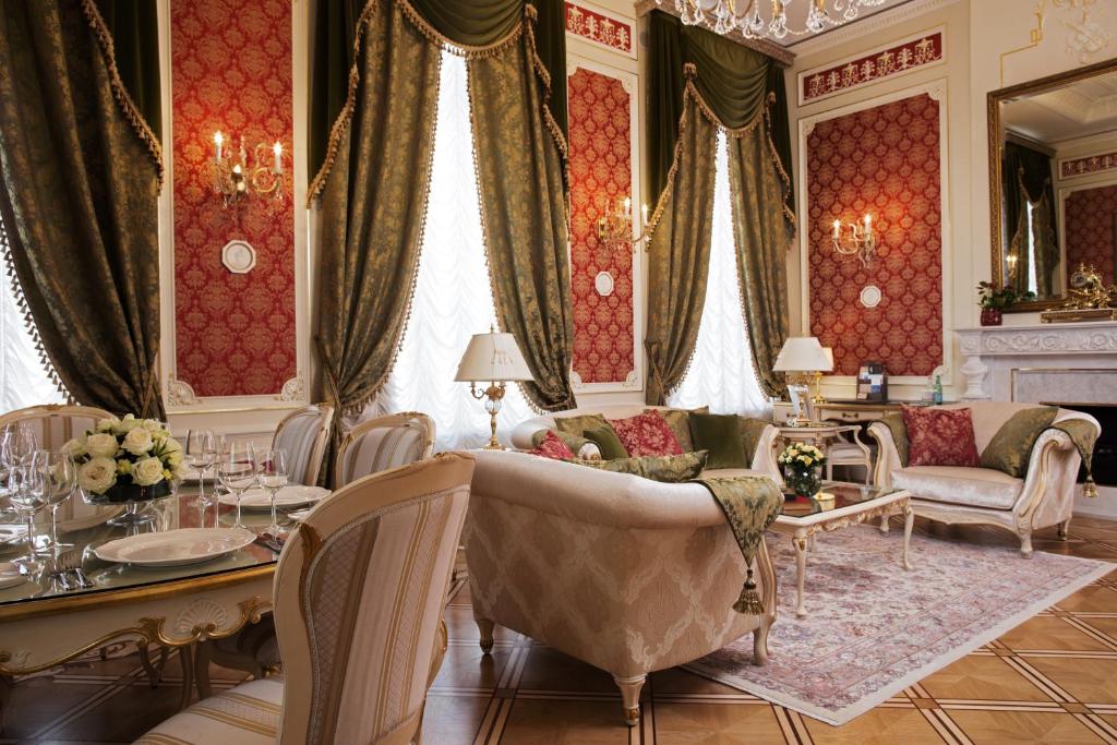 uma sala de estar com uma mesa e cadeiras e um sofá em The State Hermitage Museum Official Hotel em São Petersburgo