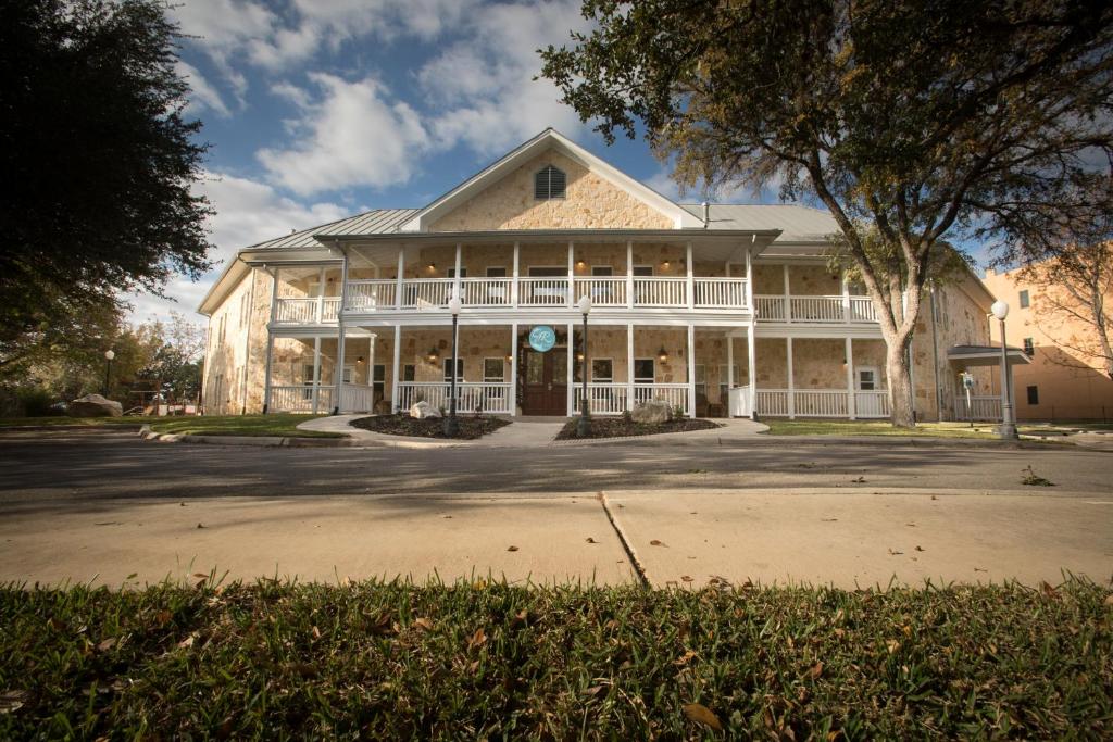 a large white house with a large porch at Gruene River Hotel & Retreat in New Braunfels