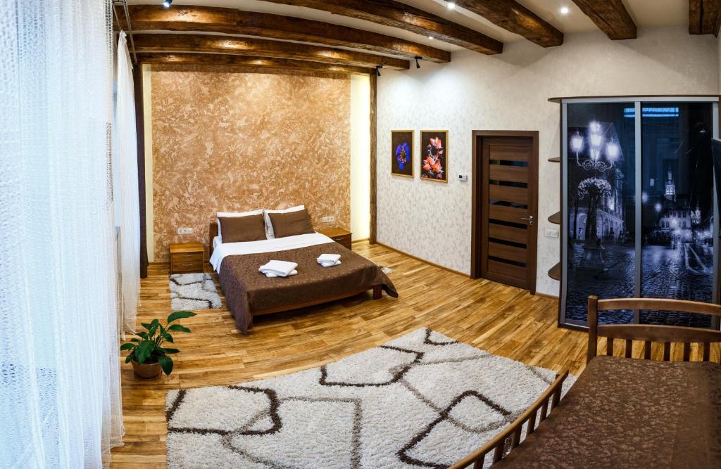ein Schlafzimmer mit einem Bett und einem Sofa in einem Zimmer in der Unterkunft Apartments "The cultural capital" VIP in Lwiw