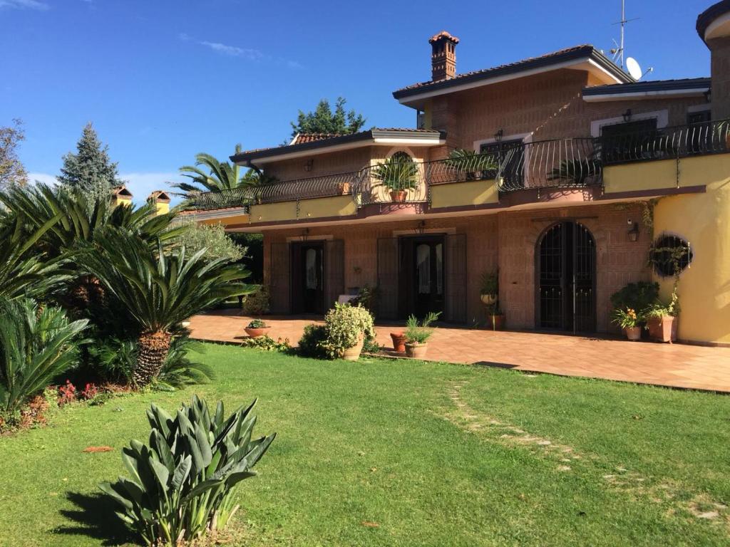 une grande maison avec une pelouse devant elle dans l'établissement Villa Luisa, à Montoro Inferiore
