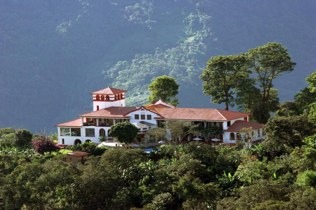una casa en una colina con una montaña en el fondo en Hotel Gloria Coroico, en Coroico