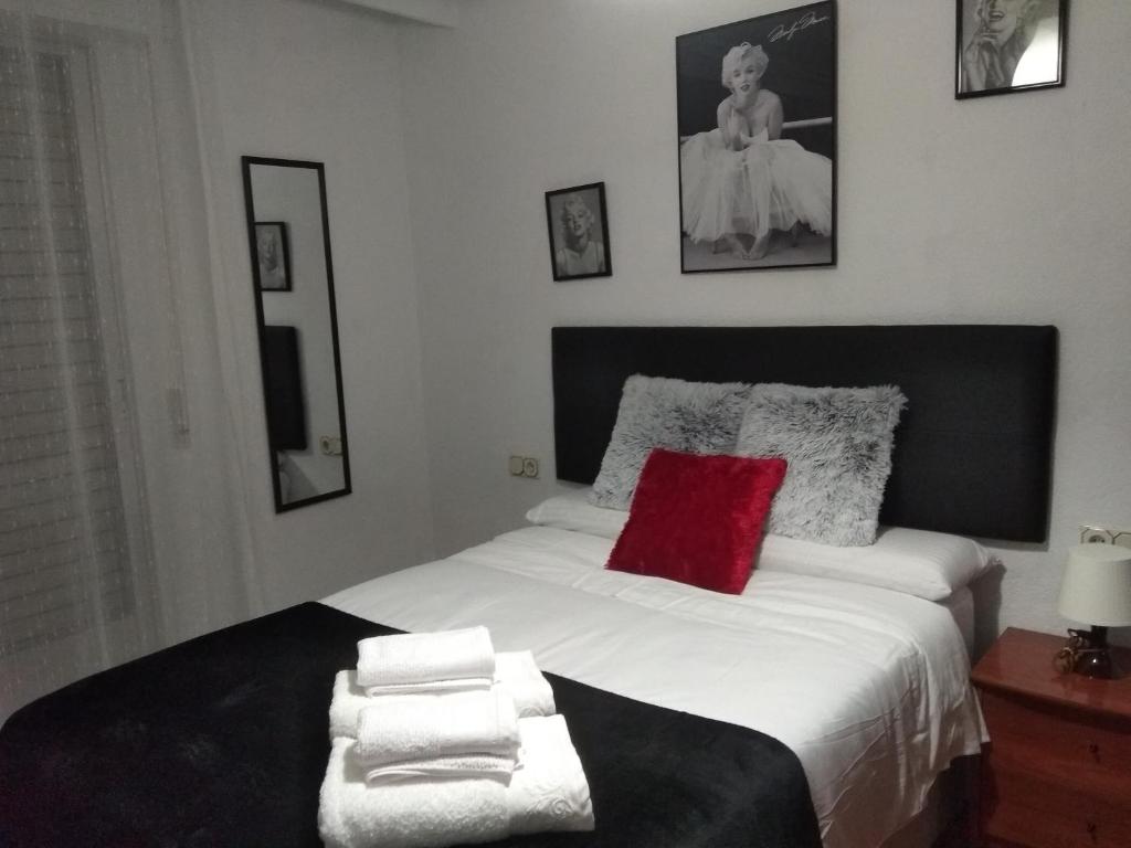 1 dormitorio con cama blanca grande y almohada roja en VuT EL GRECO, en Salamanca