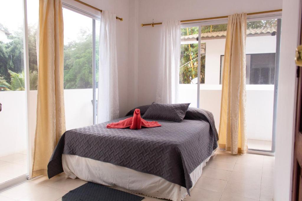 ein Schlafzimmer mit einem Bett mit einem roten Bademantel. in der Unterkunft El Paraiso in Montañita