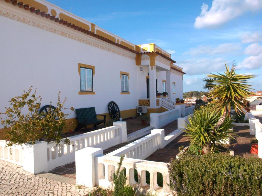 a white house with a white fence and some plants at Casa Esquível in Mourão