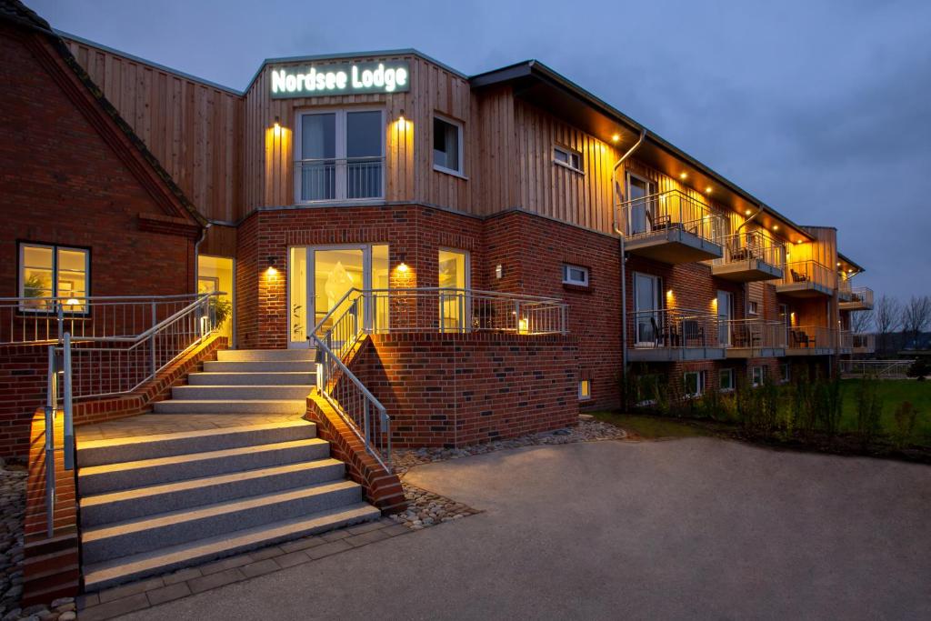 a brick building with stairs in front of it at Nordsee Lodge in Pellworm