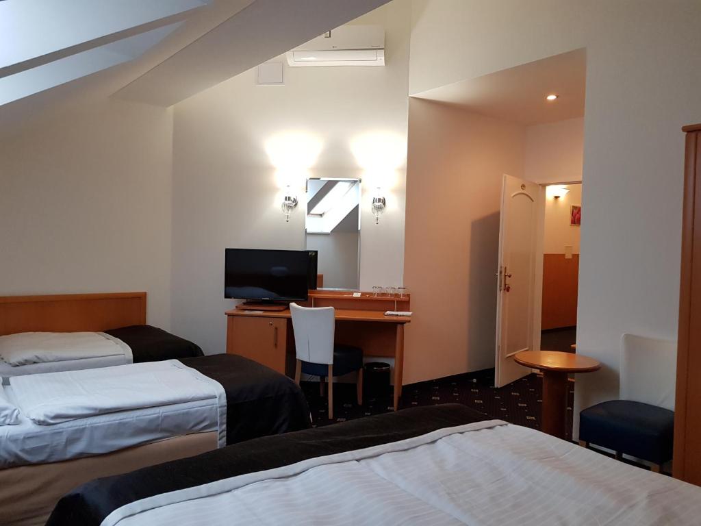 a hotel room with two beds and a desk at Máchova in Prague