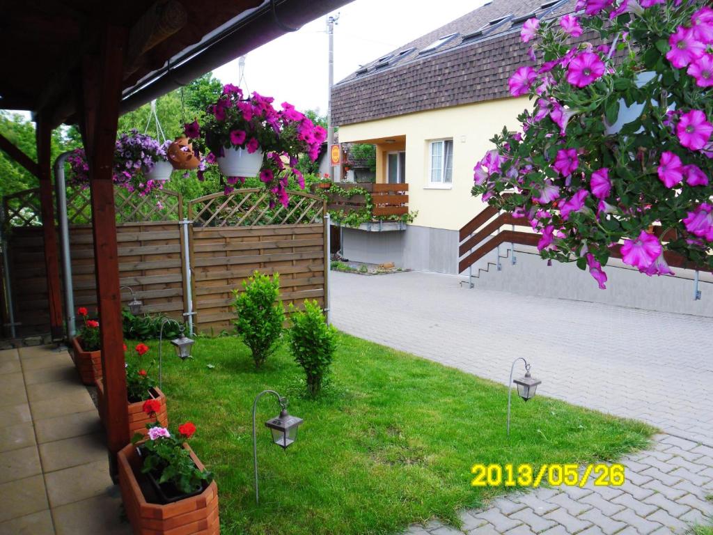 einen Garten mit Blumen in Töpfen und ein Haus in der Unterkunft Penzion Aida Ostrava in Ostrava