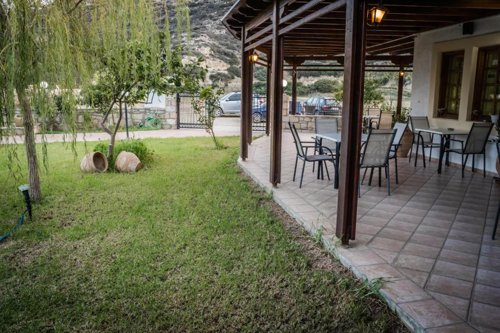 a patio with a table and chairs on the grass at Dimitris Villa Hotel in Matala