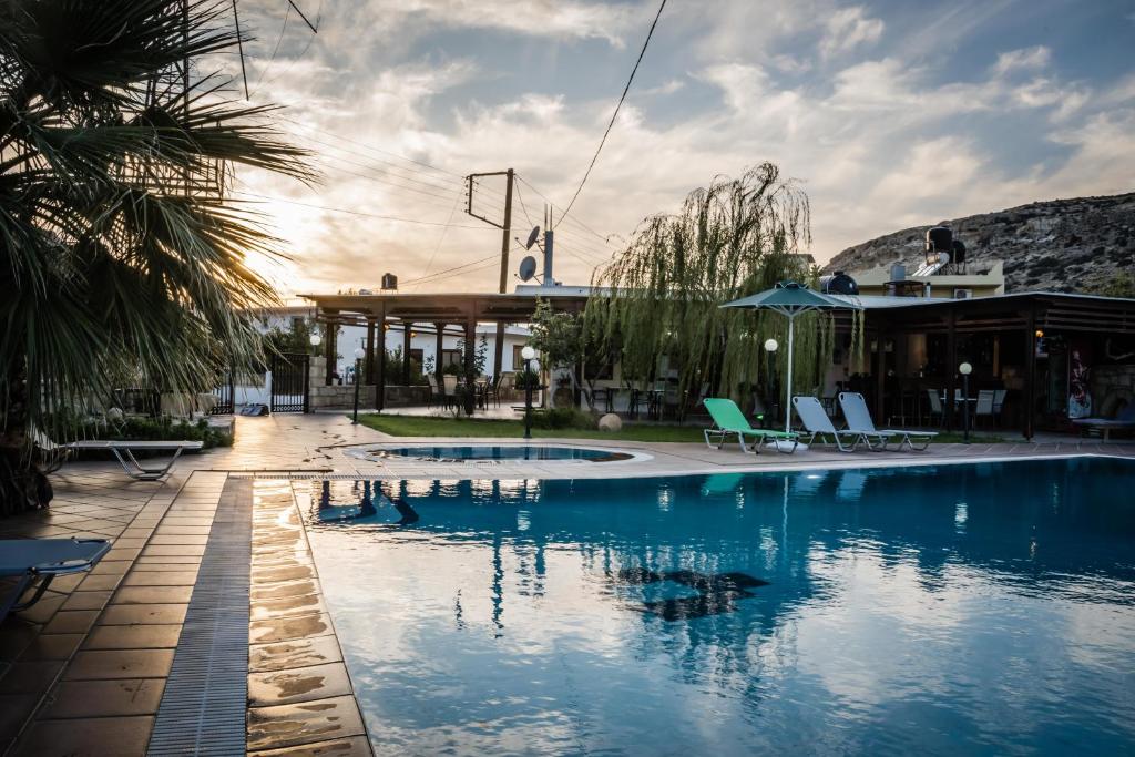 una piscina con sillas y un edificio en Dimitris Villa Hotel en Mátala
