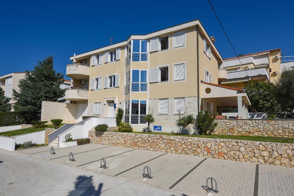 un gran edificio de apartamentos con una pared de piedra en Apartments Luaniva 50m from the see, en Novalja