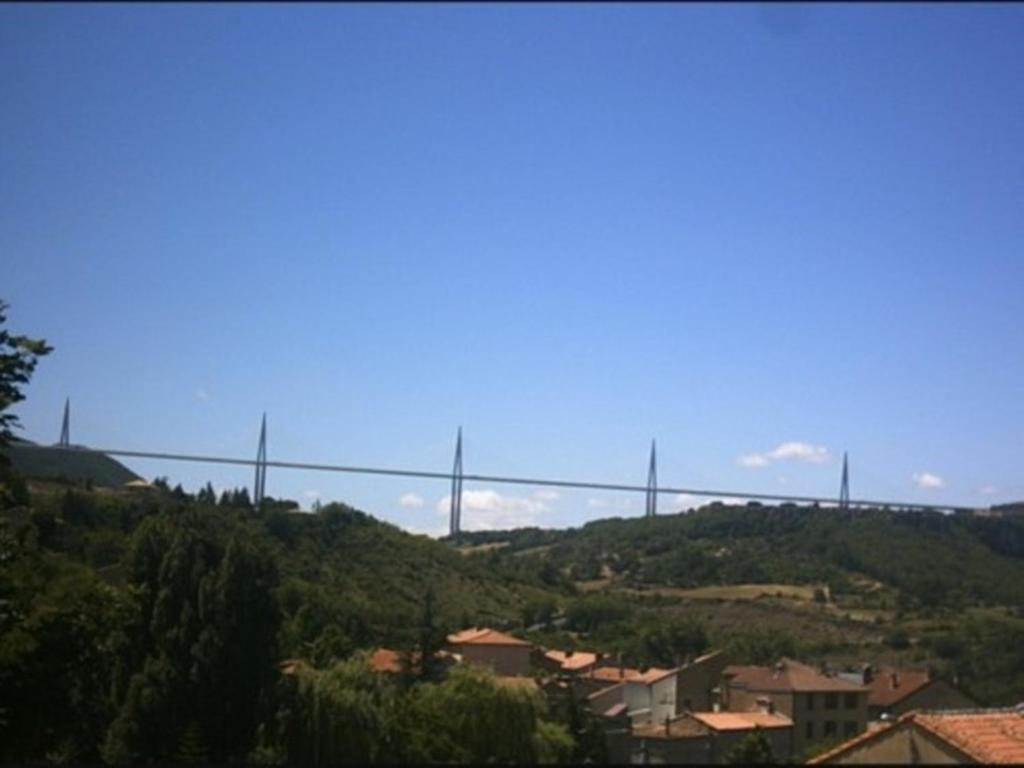 eine Brücke auf einem Hügel mit Häusern in der Unterkunft Cascades Location in Creissels