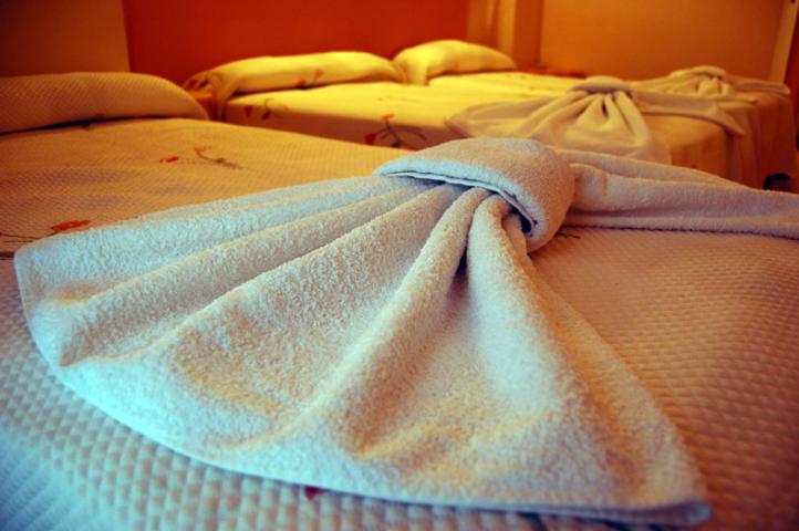 two beds with white towels on top of them at Hostal Stop in Cantalejo