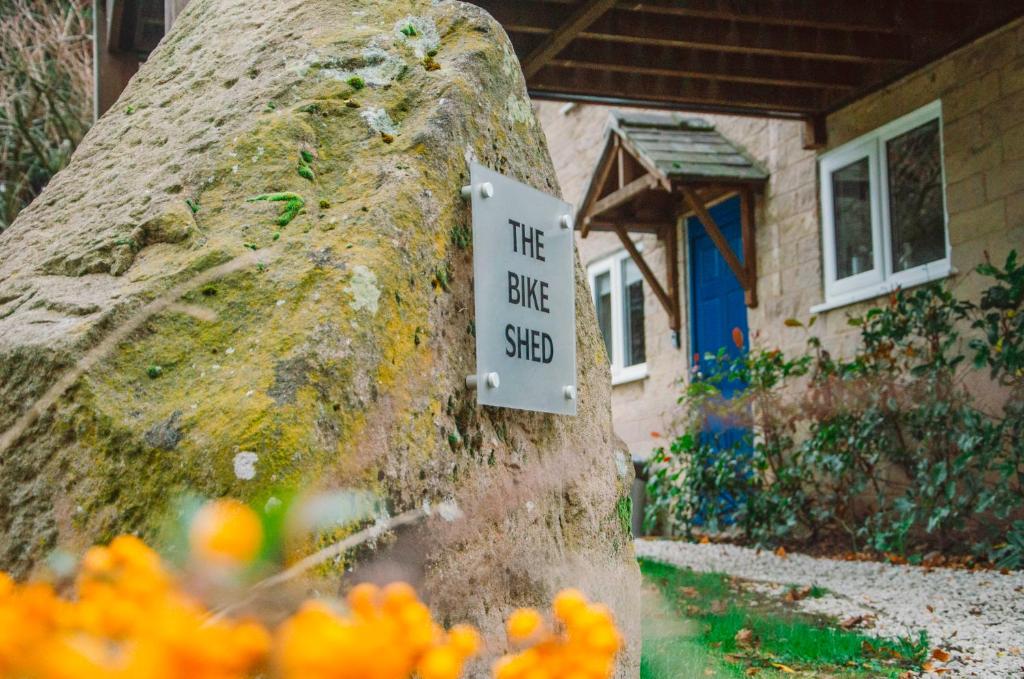 um sinal que diz que o galpão da bicicleta em uma parede de pedra em The Bike Shed em New Mills