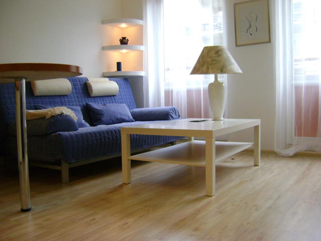 a living room with a blue couch and a table at Apartament Super Poznań in Poznań