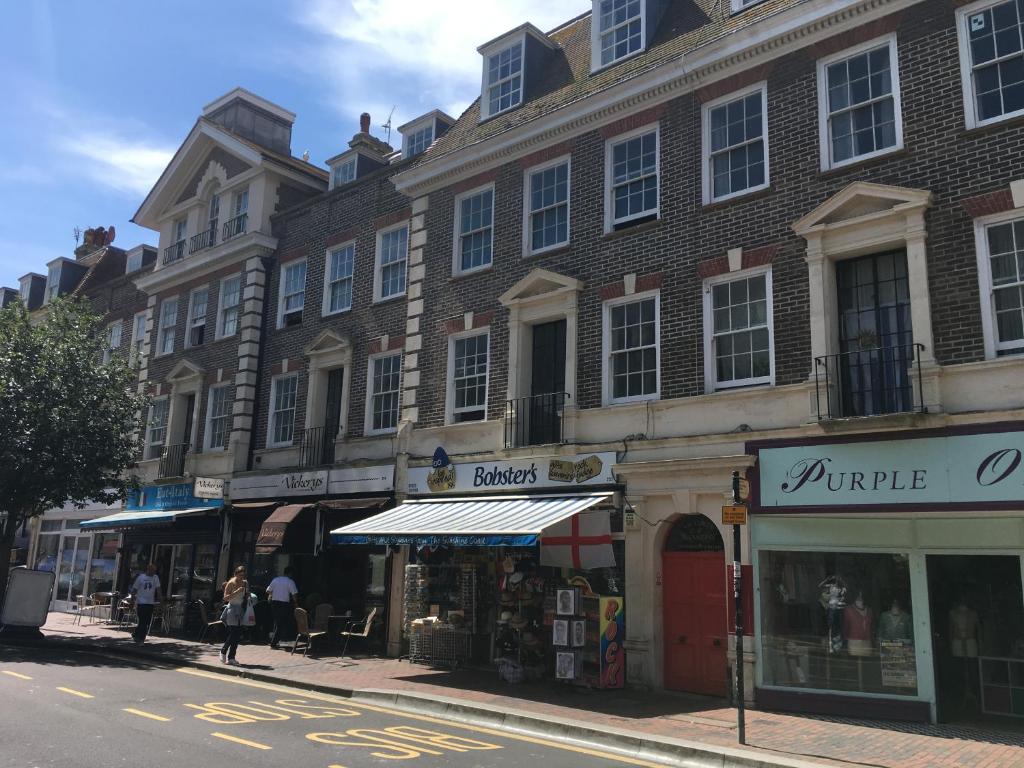 a building on a city street with people walking on the sidewalk at Victoria Mansions in Eastbourne