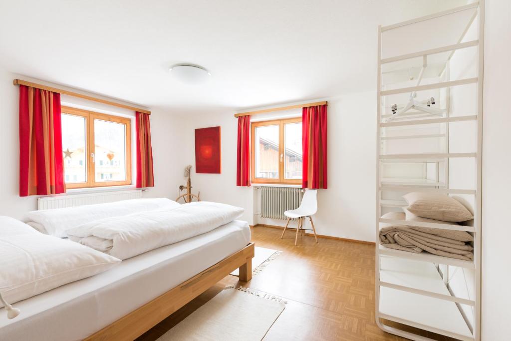 a bedroom with two beds and red curtains at Am Mellenbach Patrizia Kleber in Mellau