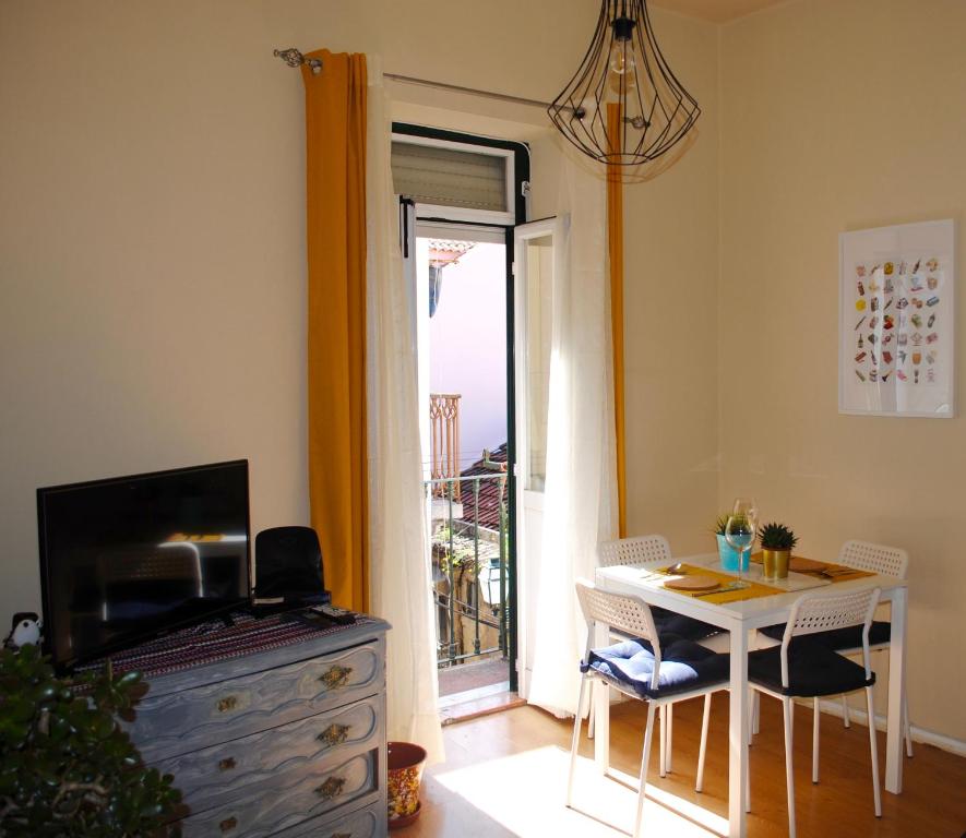 een woonkamer met een tafel, een tv en een raam bij Charming City Centre Apartment in Lissabon