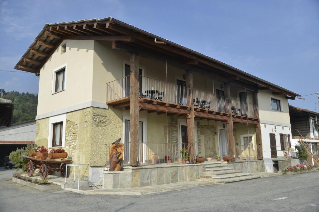 un edificio con un balcón en el lateral. en Agriturismo Ai Prüsot, en Bagnolo Piemonte