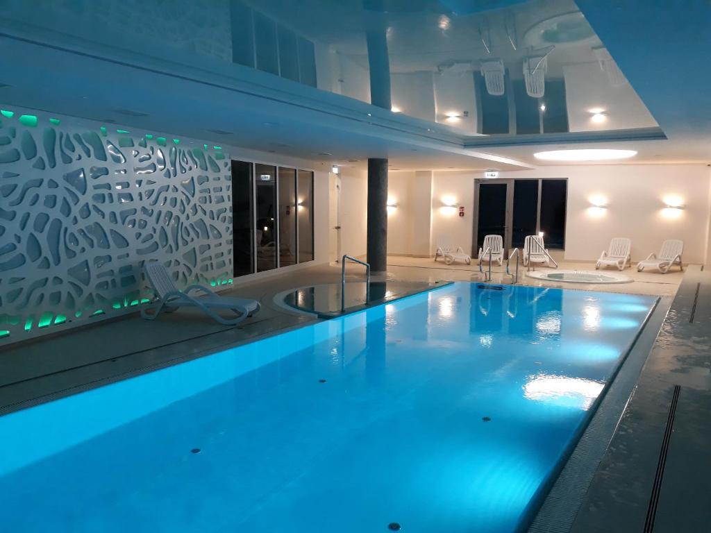 duży basen z niebieskim oświetleniem w budynku w obiekcie SeaGdansk @ Waterlane Island w Gdańsku