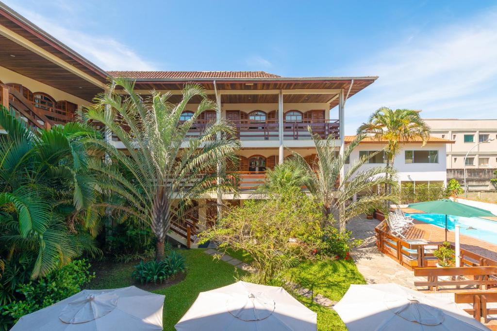 eine Außenterrasse mit Sonnenschirmen und ein Resort in der Unterkunft Chalés Four Seasons in Ubatuba