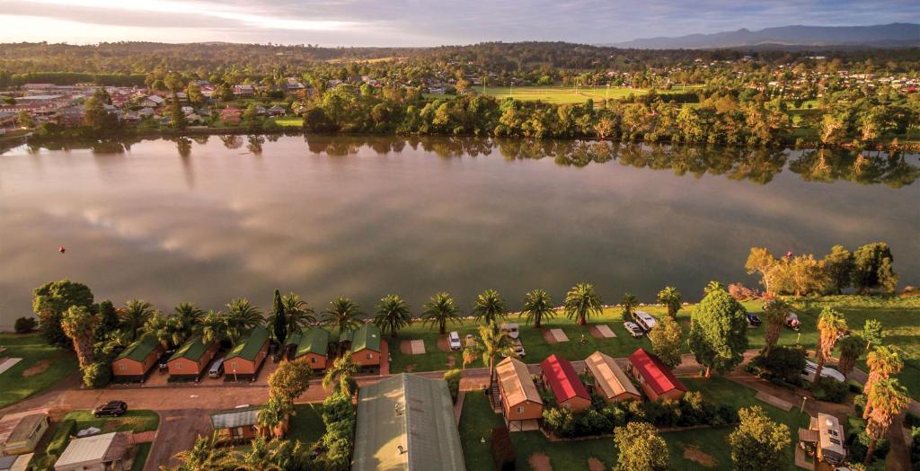 an aerial view of a lake with houses and palm trees at Ingenia Holidays Moruya in Moruya